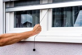 Wartung - Hand hält Anti-Insekten-Moskitonetz auf PVC-Fenster Insektenschutz Rollo