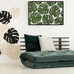 Wohnzimmer - Plakat der Blätter über Futon mit Kissen in modernen Schlafzimmer Innenraum mit Tisch. Echtes Foto - Stock-Fotografie