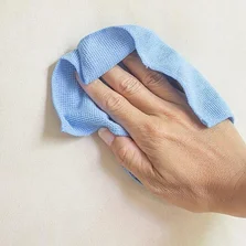 Pflegeleicht - Cremige Stoff mit Mikrofaser-Tuch reinigen - Stock-Fotografie